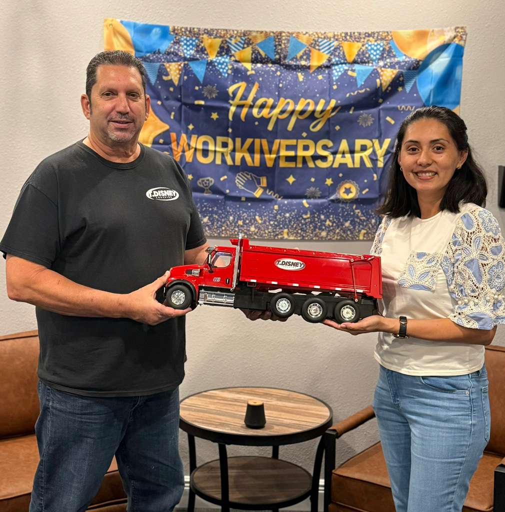 Joe Valdez and Stefanie Martin holding a model T. Disney dump truck