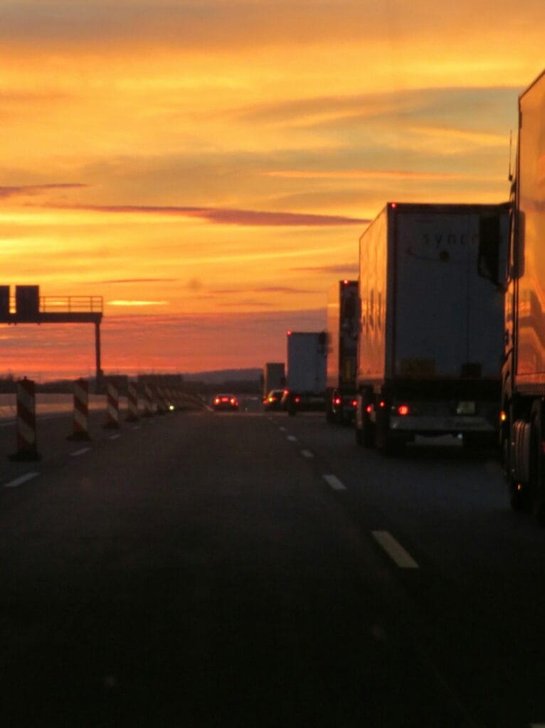 Semi truck driving on highway at sunset