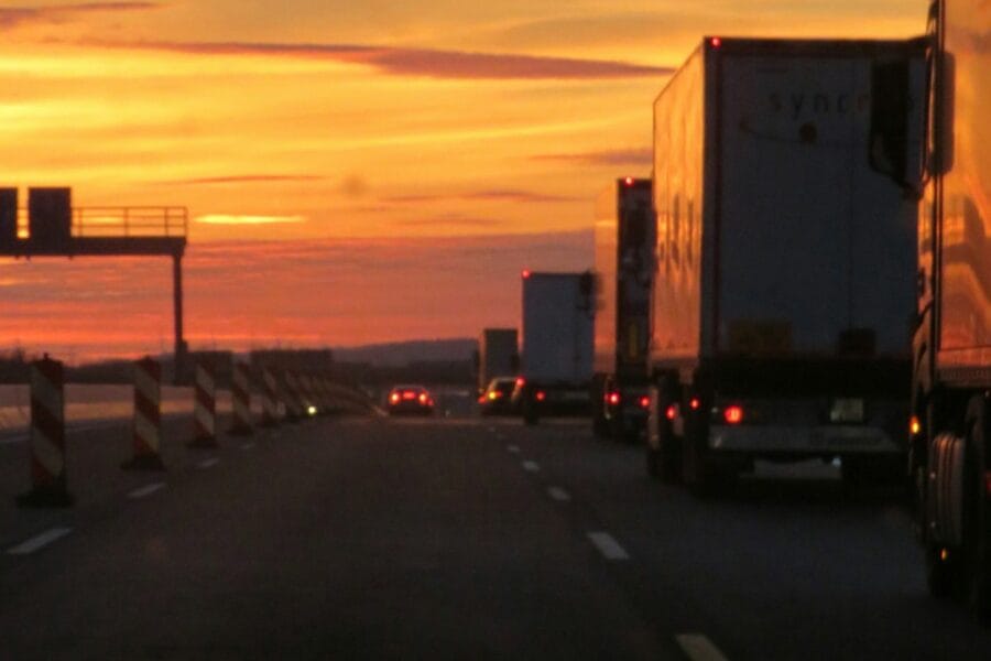 Semi truck driving on highway at sunset
